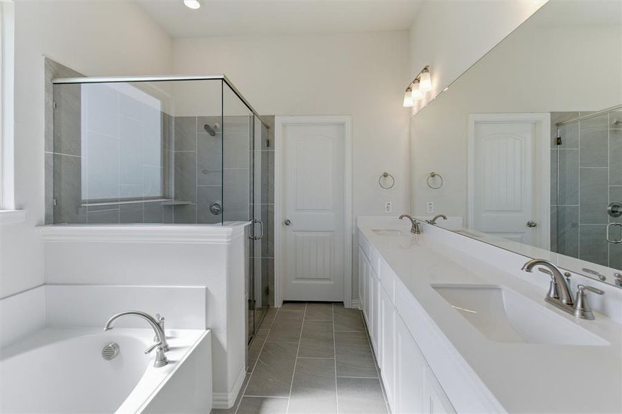 Contemporary bathroom featuring a spacious walk-in shower with glass enclosure and tiled walls, a separate soaking tub, a dual vanity with integrated sinks and brushed nickel faucets, and coordinating floor tiling