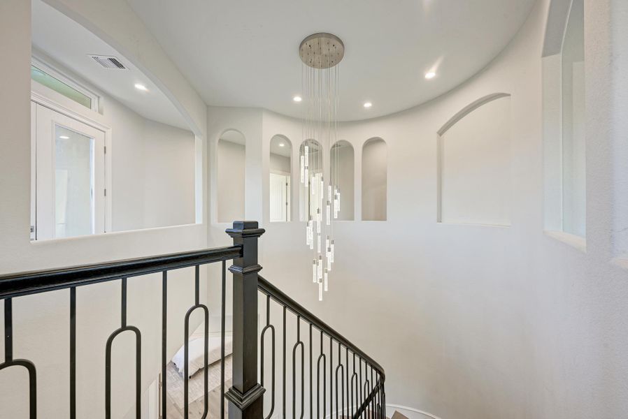 Hall with recessed lighting and an upstairs landing