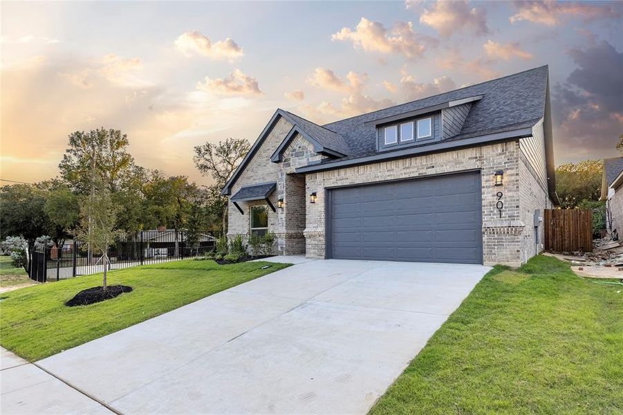 French country home with brick siding, concrete driveway, a shingled roof, and an attached garage