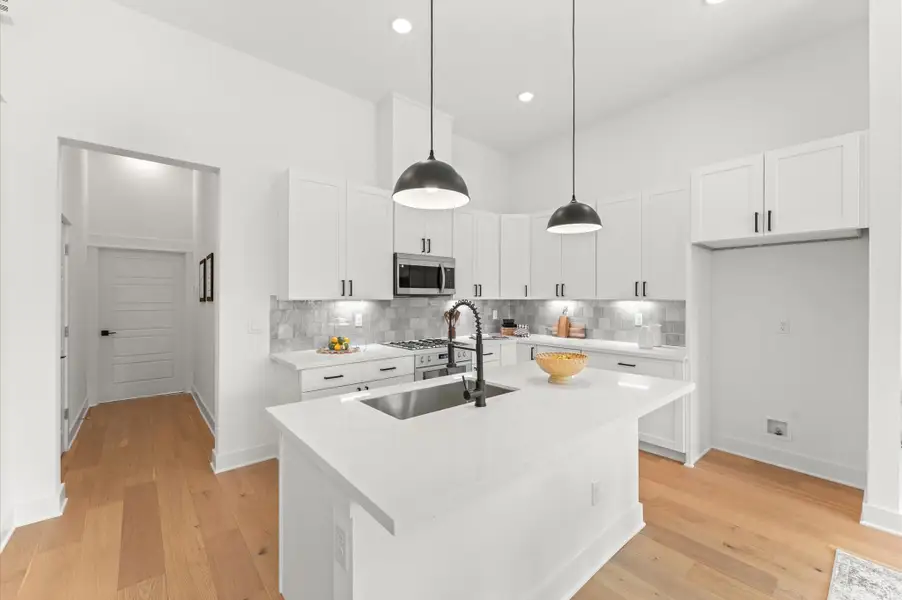 Striking kitchen island serves as the centerpiece of this open-concept space, offering both style and functionality. Topped with sleek quartz, the island includes bar seating for casual dining, ample storage with built-in cabinetry, and a spacious prep surface ideal for entertaining or everyday cooking. Pendant lighting overhead adds a touch of elegance, while the island’s placement encourages seamless flow between the kitchen, dining, and living areas. Striking kitchen island serves as the centerpiece of this open-concept space, offering both style and functionality. Topped with sleek quartz, the island includes bar seating for casual dining, ample storage with built-in cabinetry, and a spacious prep surface ideal for entertaining or everyday cooking. Pendant lighting overhead adds a touch of elegance, while the island’s placement encourages seamless flow between the kitchen, dining, and living areas.