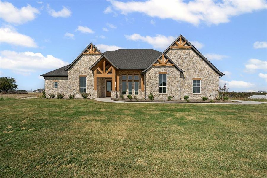 Craftsman house featuring a porch, stone siding, and a front lawn