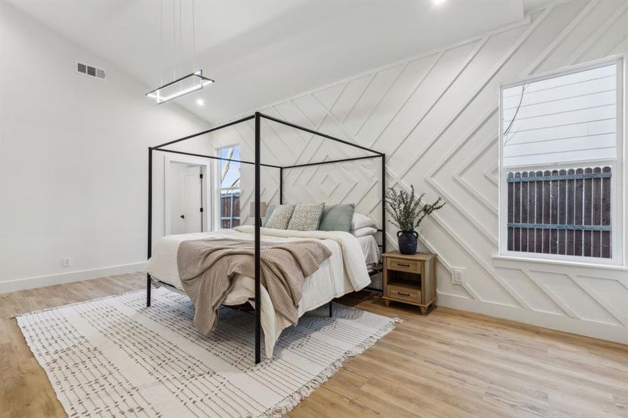 Bedroom with light wood-type flooring and vaulted ceiling