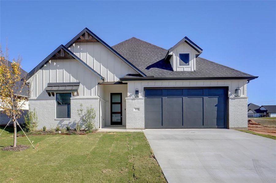 View of front of home with a front yard and a garage