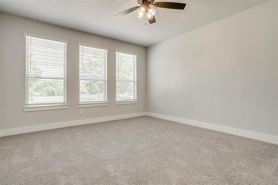 Carpeted spare room with ceiling fan