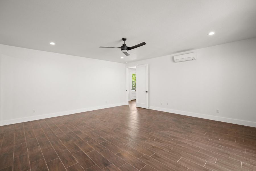 Empty room featuring recessed lighting, dark wood-style floors, a ceiling fan, and a wall unit AC