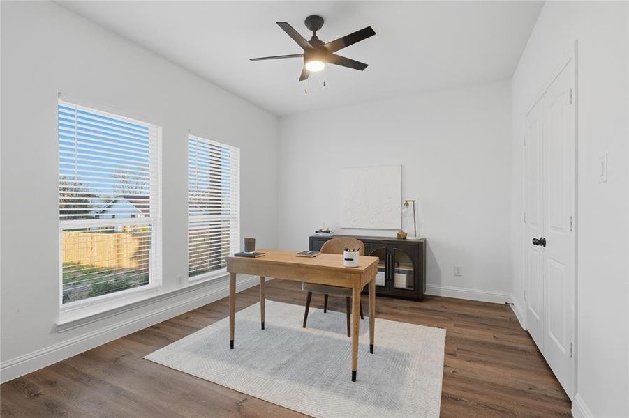 Office area with ceiling fan and dark wood-style floors