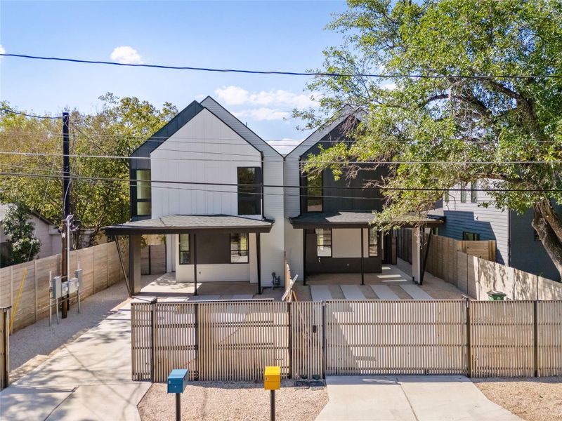 Modern home featuring a fenced front yard and a gate