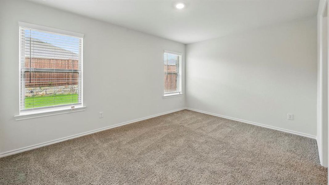 Neutral-toned interior room featuring carpet flooring, two windows with blinds, recessed lighting, and white baseboards