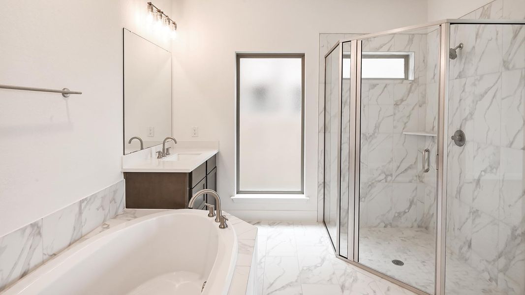 Full bathroom featuring a marble finish shower, vanity, a bath, and marble finish floors