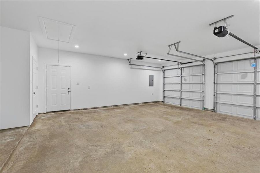 Full size Pickup Truck? No problem.  Oversized garage featuring two overhead doors with automatic openers, a pedestrian entry door, an access panel on the ceiling, and recessed lighting.