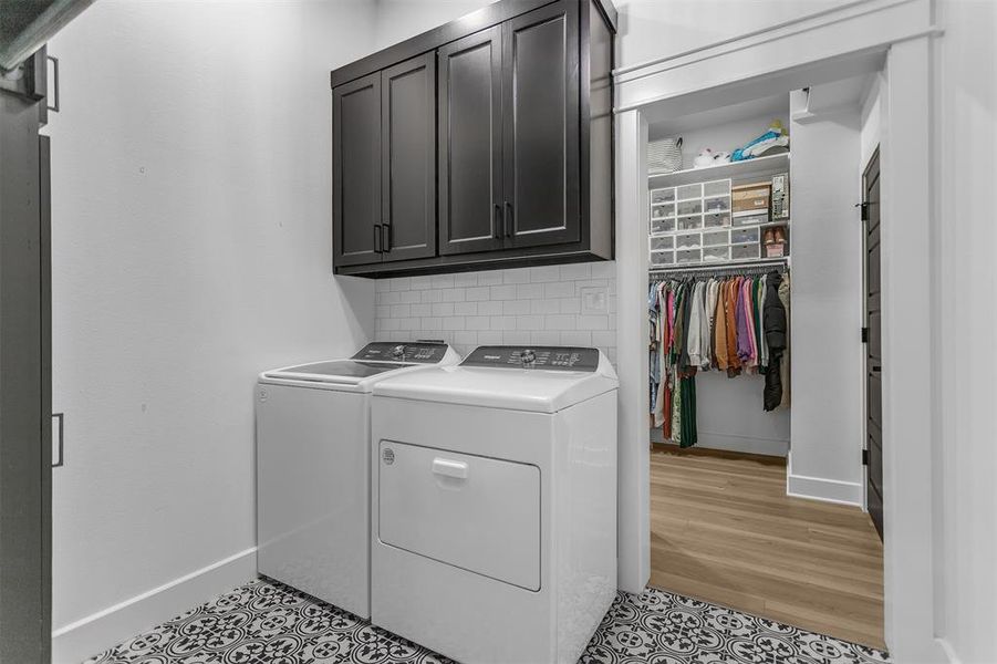 Laundry room just off the primary closet accented by custom storage units and french-style tile. Laundry room just off the primary closet accented by custom storage units and french-style tile.