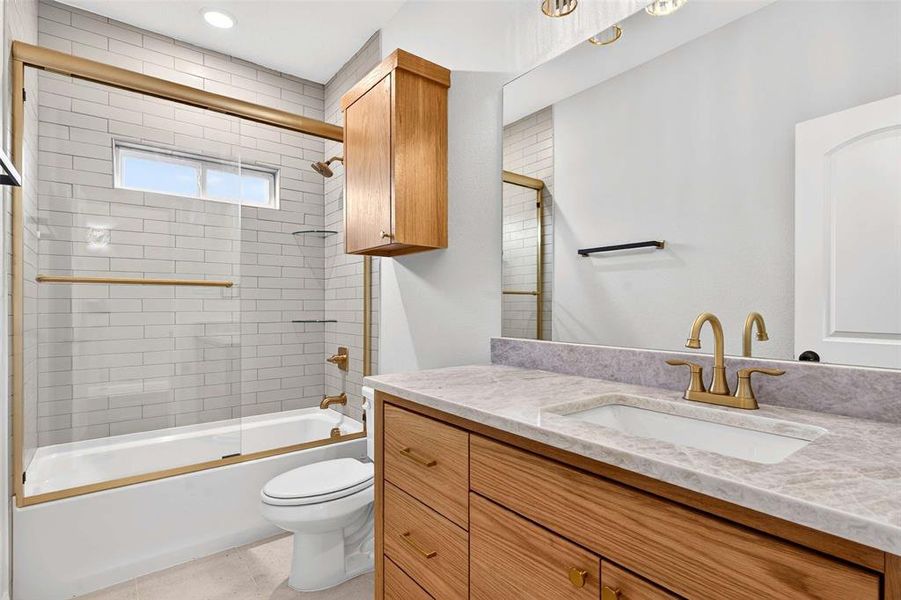 Full bathroom featuring combined bath / shower with glass door, vanity, light tile patterned flooring, and recessed lighting