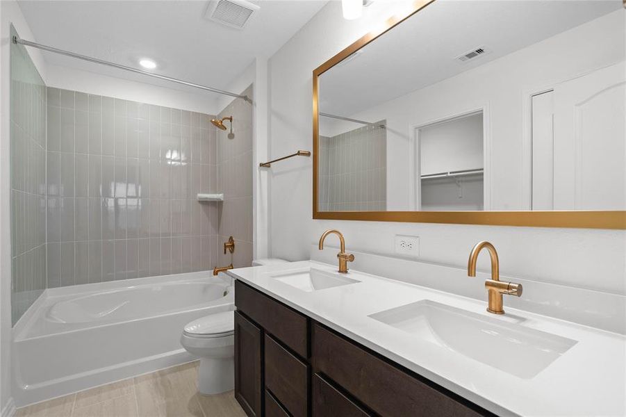 This primary bathroom is definitely move-in ready! Featuring an oversized tub/shower combo, stained cabinets with light countertops, high ceilings, custom paint, sleek and modern finishes, and framed mirror!