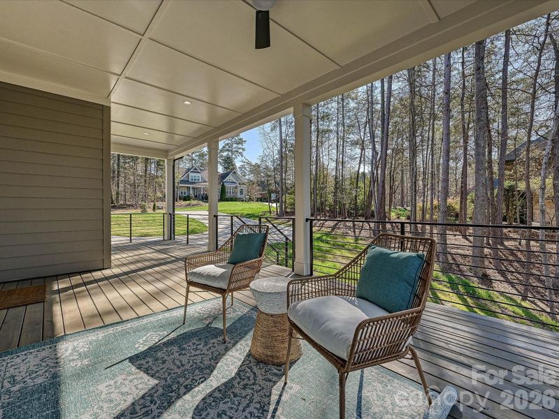 Spacious covered deck overlooking a private wooded backdrop, perfect for relaxing, entertaining, and enjoying peaceful outdoor living year-round.