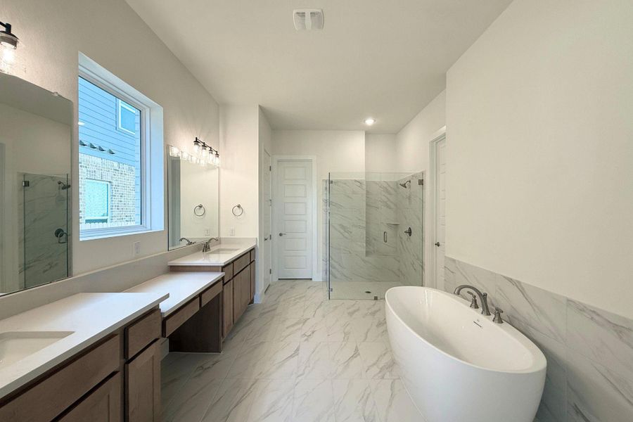 Luxurious bathing quarters feature a contemporary freestanding tub and an oversized glass-enclosed shower. Luxurious bathing quarters feature a contemporary freestanding tub and an oversized glass-enclosed shower.