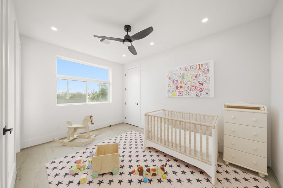 The second bedroom features hardwood floors, recessed lights, a large sliding window with a transom window above, a ceiling fan with integrated light and a walk-in closet. his photo has been virtually staged.