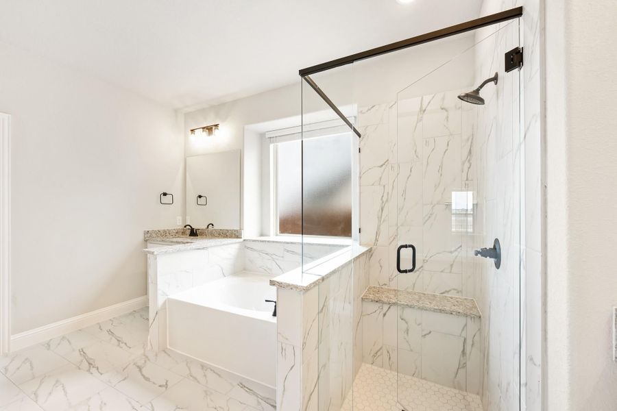 Bathroom with marble tile, soaking tub, glass-enclosed shower, and double vanity with granite countertop Bathroom with marble tile, soaking tub, glass-enclosed shower, and double vanity with granite countertop