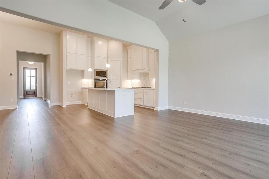 Kitchen featuring ceiling fan, built in microwave, light hardwood / wood-style floors, and wall oven