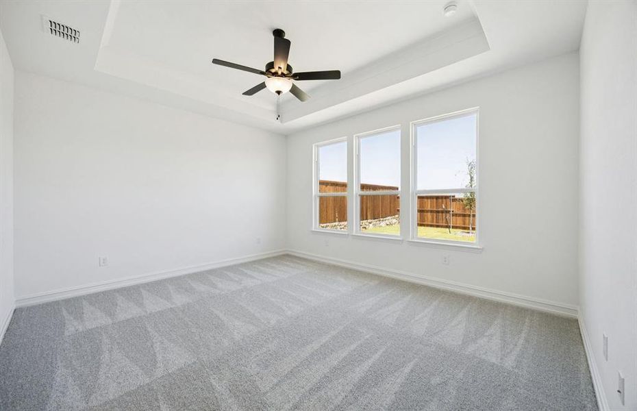 Elegant owner's suite with tray ceiling *real home pictured