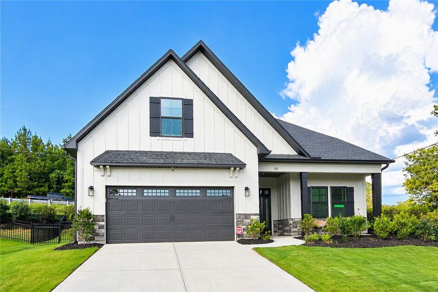 A modern farmhouse facade with a charcoal garage a A modern farmhouse facade with a charcoal garage a
