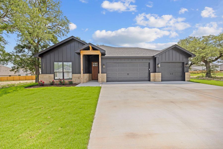 A striking modern farmhouse façade welcomes you, blending board and batten siding with stone accents. A striking modern farmhouse façade welcomes you, blending board and batten siding with stone accents.