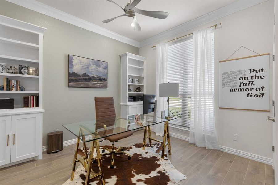 Office space with light wood-type flooring, ornamental molding, built in features, and ceiling fan Office space with light wood-type flooring, ornamental molding, built in features, and ceiling fan