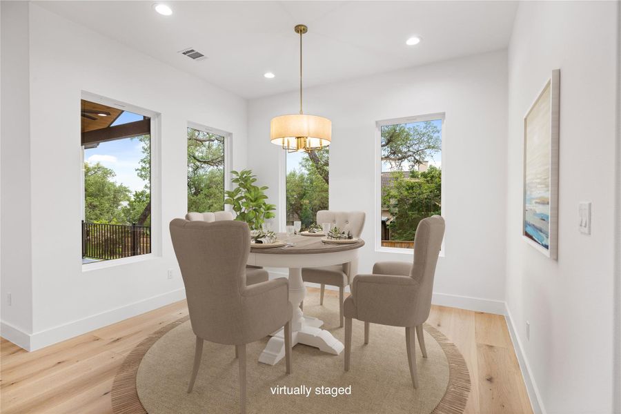 Dining space featuring light wood-style flooring, natural light, view of landscaped back yard. Virtually staged. Dining space featuring light wood-style flooring, natural light, view of landscaped back yard. Virtually staged.