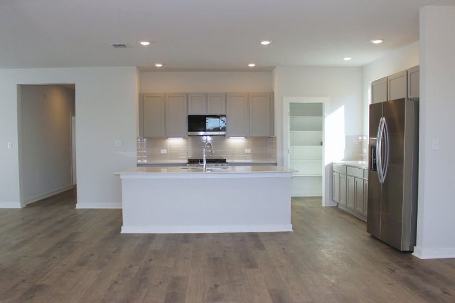 A kitchen with white cabinets.