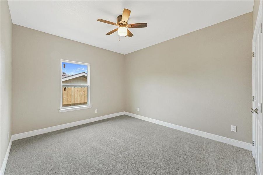 Carpeted spare room featuring baseboards and ceiling fan Carpeted spare room featuring baseboards and ceiling fan