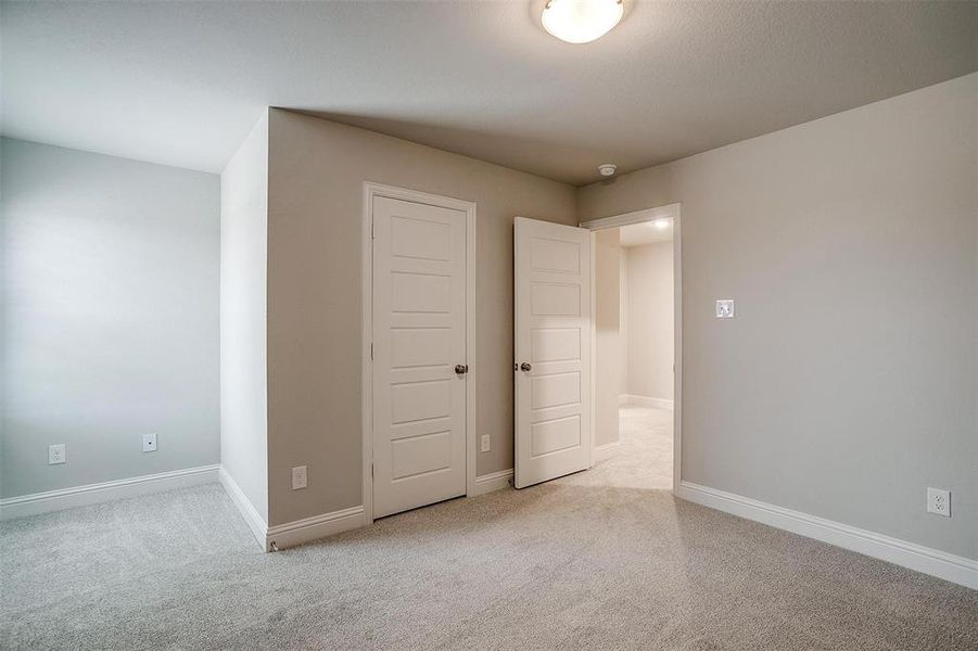 Unfurnished bedroom with carpet floors and baseboards