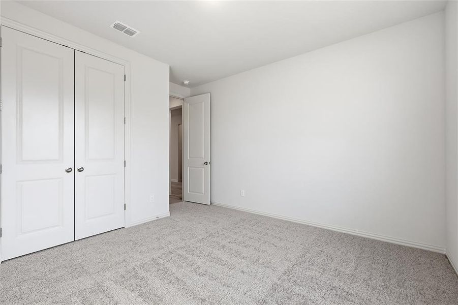 Unfurnished bedroom featuring carpet flooring and a closet Unfurnished bedroom featuring carpet flooring and a closet