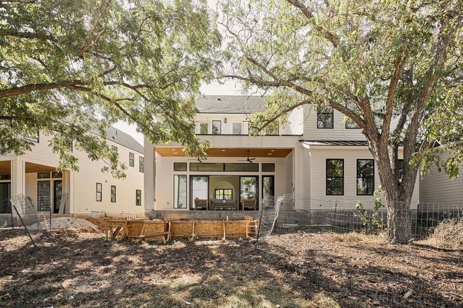 Rear view of property featuring a standing seam roof, a metal roof, and ceiling fan Rear view of property featuring a standing seam roof, a metal roof, and ceiling fan