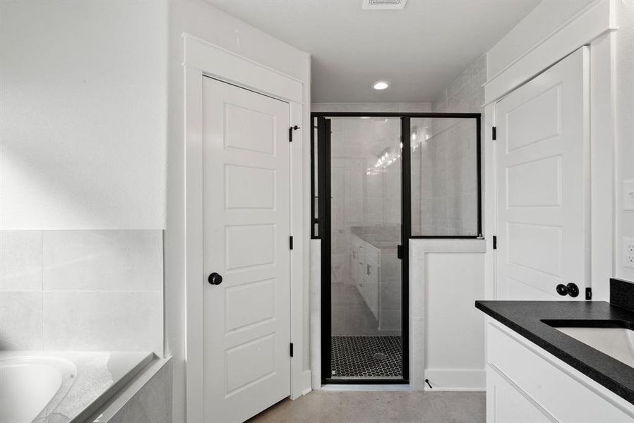 Bathroom featuring vanity and independent shower and bath