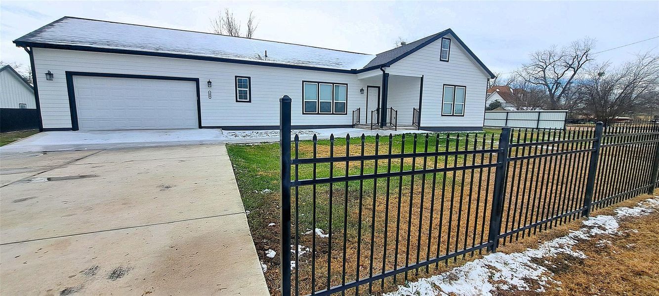 View of front of home with driveway, a garage, and a fenced front yard