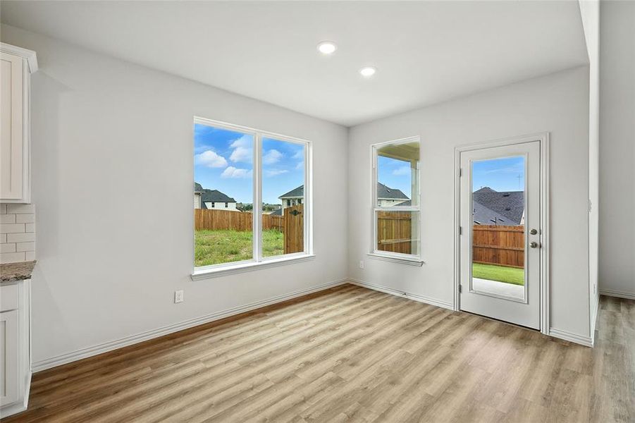 Unfurnished dining area featuring light wood-type flooring and recessed lighting