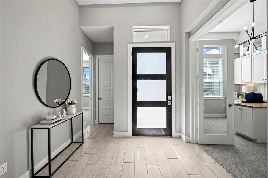 Welcome to a bright and inviting foyer, featuring sleek modern finishes and a seamless flow into the heart of the home.