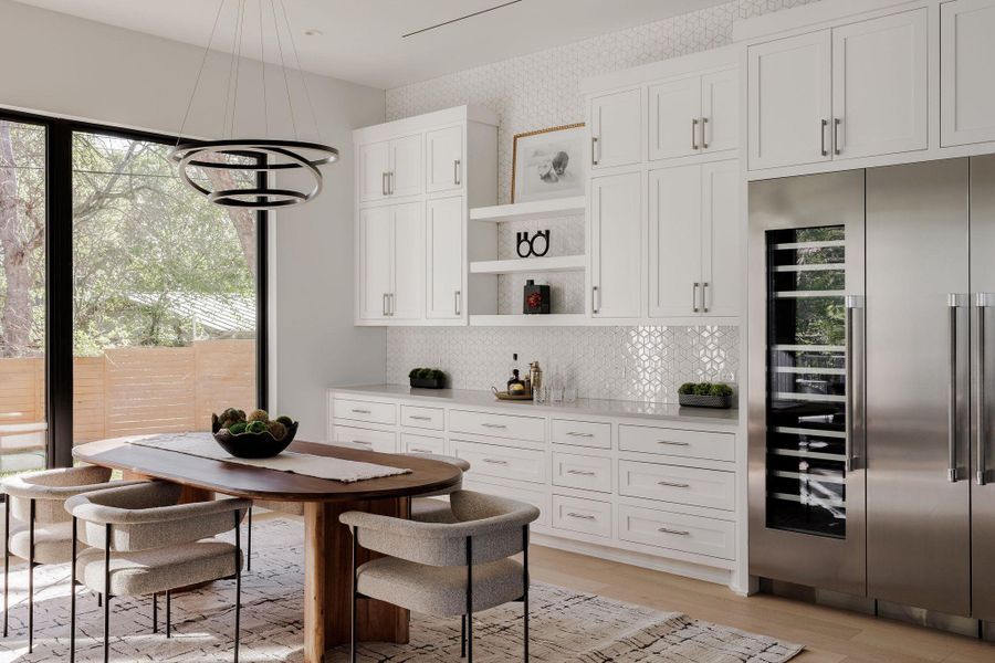 The dining area connects effortlessly to the outdoors, reinforcing the home’s indoor-outdoor lifestyle. The added built-in buffet is a true addition to the kitchen storage. The dining area connects effortlessly to the outdoors, reinforcing the home’s indoor-outdoor lifestyle. The added built-in buffet is a true addition to the kitchen storage.