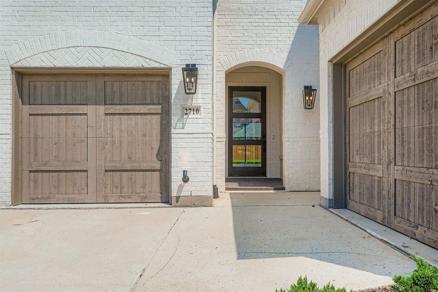 Property entrance featuring brick siding and driveway Property entrance featuring brick siding and driveway