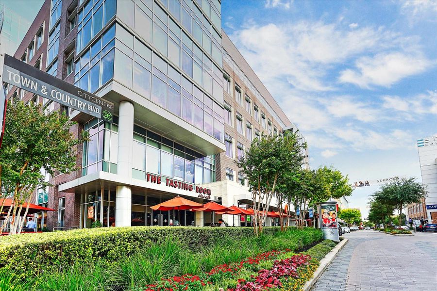 Tree-lined boulevard in the heart of Town & Country in CityCentre featuring modern mixed-use architecture, inviting patios, and curated landscaping. Wide pedestrian pathways and vibrant storefronts create a refined yet relaxed environment. This walkable district offers seamless access to dining, boutique shopping, and professional offices in a polished urban setting.