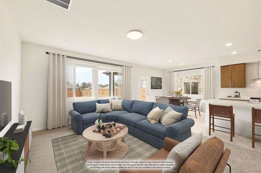 Open-concept living room with blue sectional sofa, connected dining area and kitchen visible in background Open-concept living room with blue sectional sofa, connected dining area and kitchen visible in background