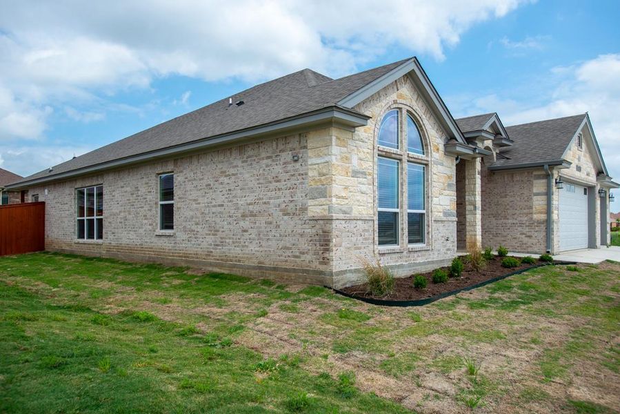 View of side of home with brick siding, a garage, and roof with shingles View of side of home with brick siding, a garage, and roof with shingles