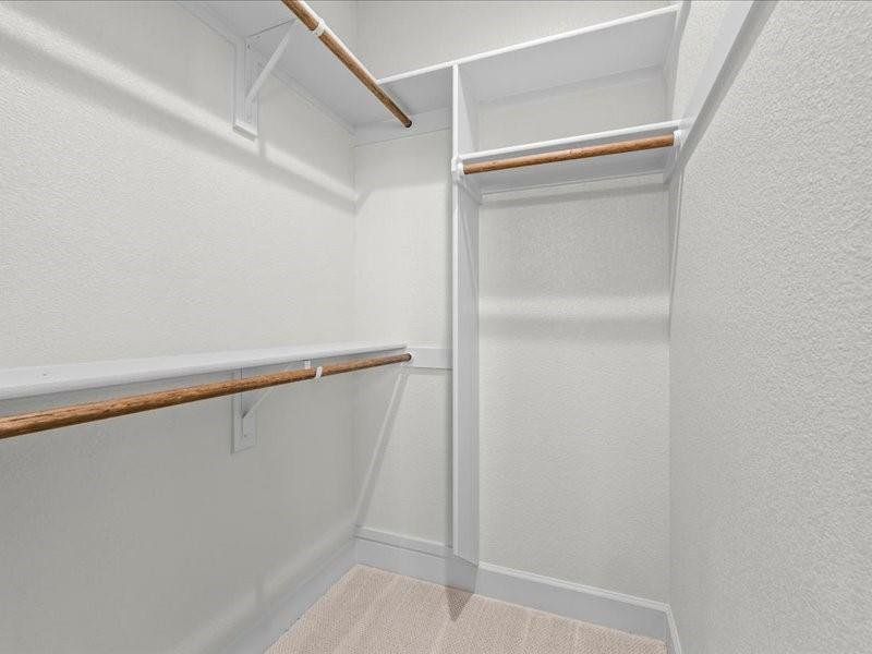 Spacious closet with light colored carpet Spacious closet with light colored carpet
