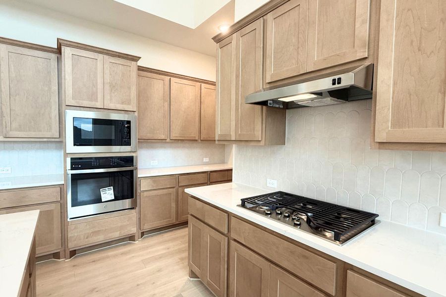 Culinary aspirations come alive in this well-appointed kitchen featuring light-toned cabinetry and integrated appliances. Culinary aspirations come alive in this well-appointed kitchen featuring light-toned cabinetry and integrated appliances.