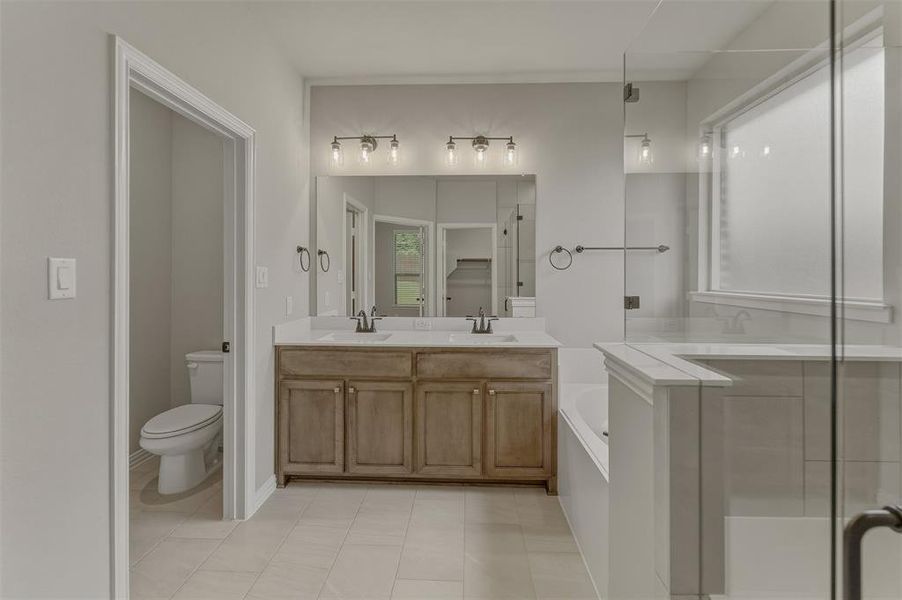 Bathroom featuring dual wood-finish vanity with stone countertops, undermount sinks, and individual mirrors