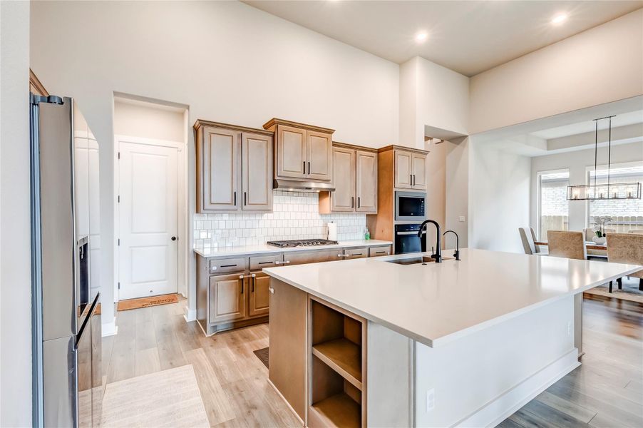 An open-concept kitchen features a spacious island with ample counter space, alongside modern appliances and stylish cabinetry.