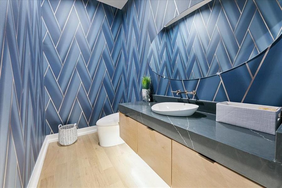Bathroom with wood finished floors, vanity, and tile walls