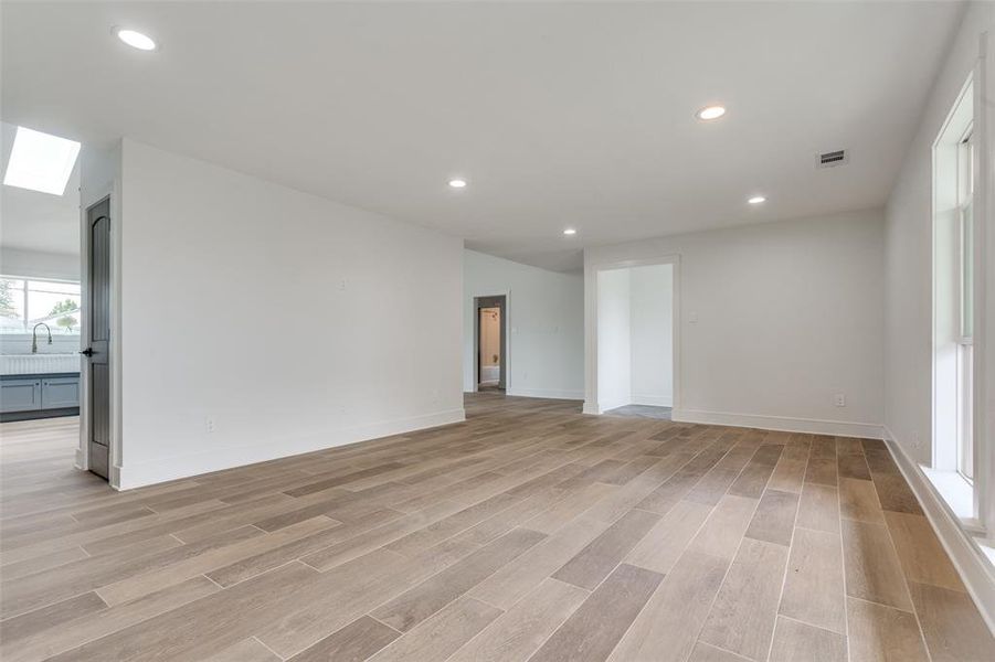 Nice shot showing the corner of the living room facing the door with the sneak look into the gourmet chef's kitchen.