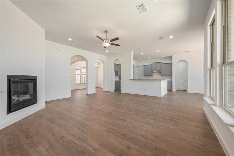 Unfurnished living room with dark wood-type flooring and ceiling fan