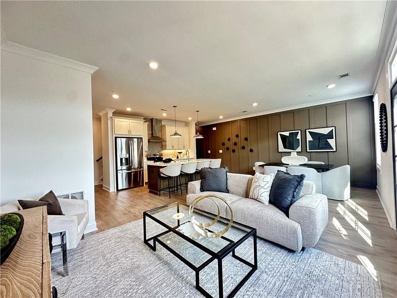 Living room baseboards, crown molding, light wood finished floors, and recessed lighting *Photos Showcase Warm Wheat Design Collection from a different Staged Model Home Site*