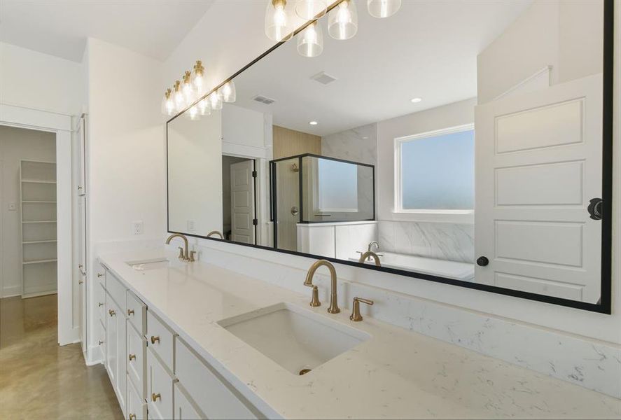 Full bath featuring a stall shower, double vanity, a spacious closet, a garden tub, and concrete floors